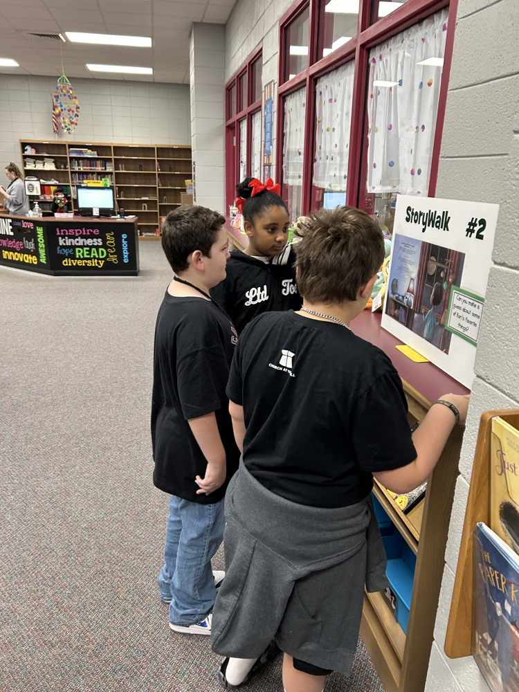 students reading StoryWalk signs