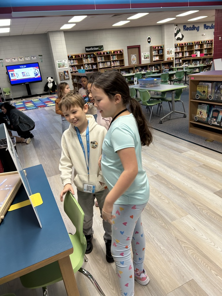 students reading StoryWalk signs
