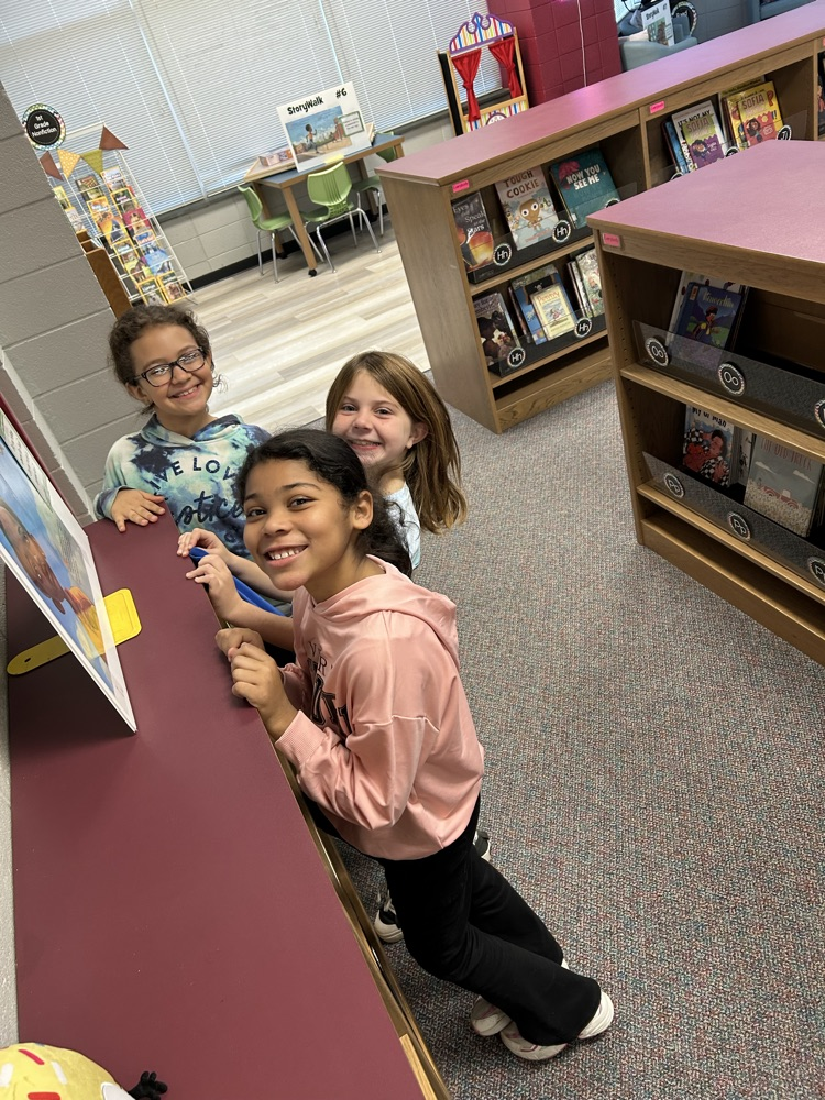 students reading StoryWalk signs