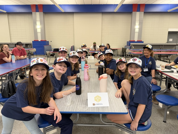 students grouped around a long table 
