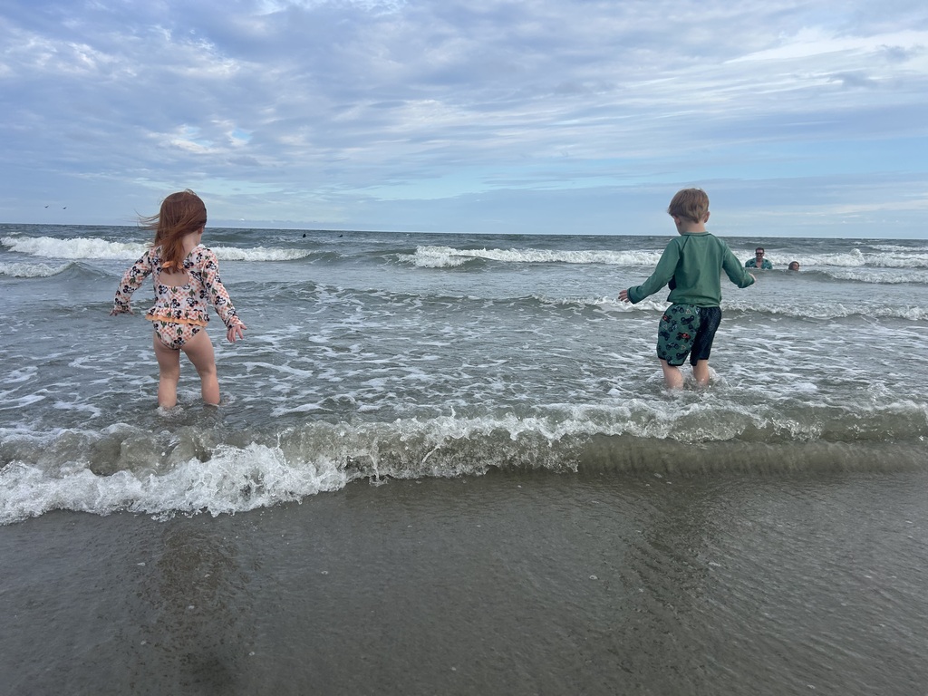 Students playing in waves