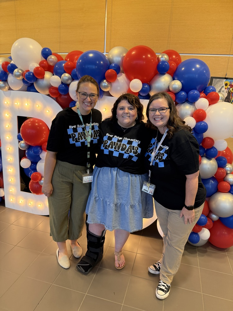 Our Special Education team smiling in front of a display of balloons and a large letter D and number 5