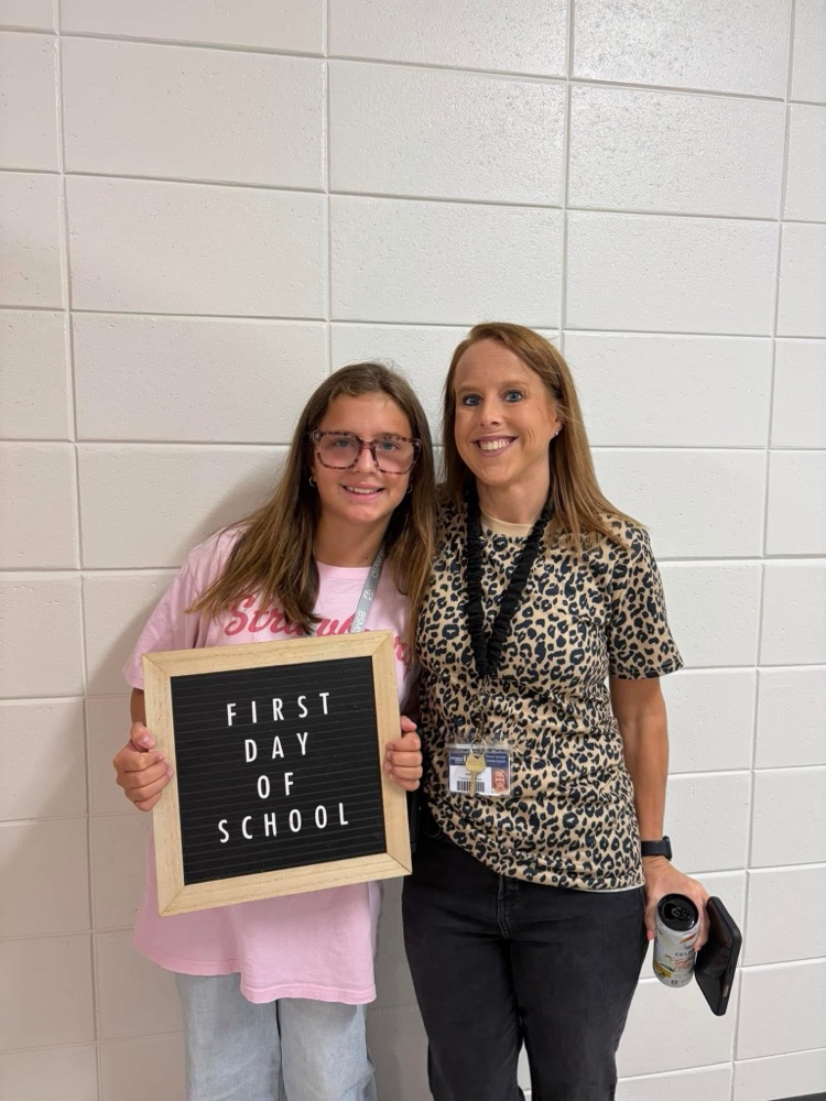 student and teacher holding up a sign