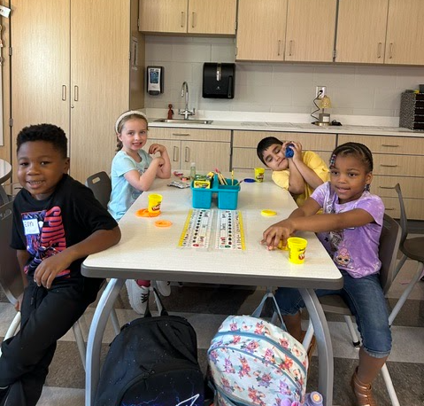 This image includes kindergarten students playing with play dough.