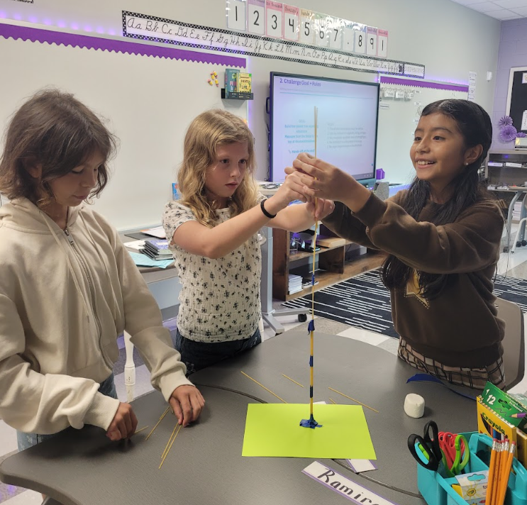 This picture includes students completing a group project and building a spaghetti tower.