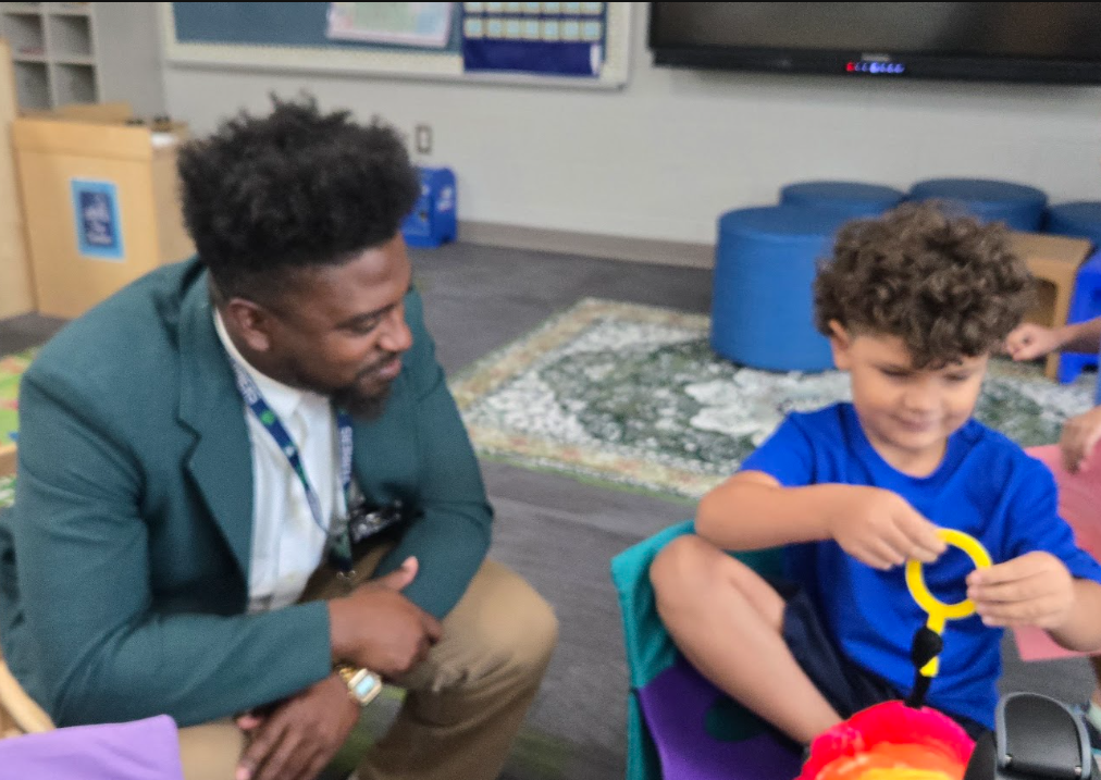 This image is a picture of school counselor, Aaron Watson, playing with a student.