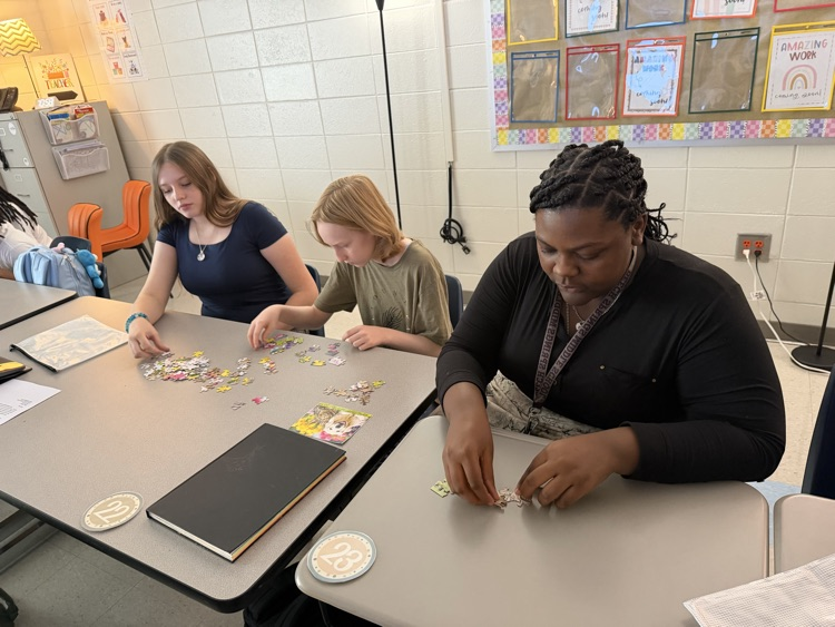 three students working on a puzzle