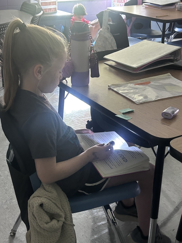 students reading by flashlight 