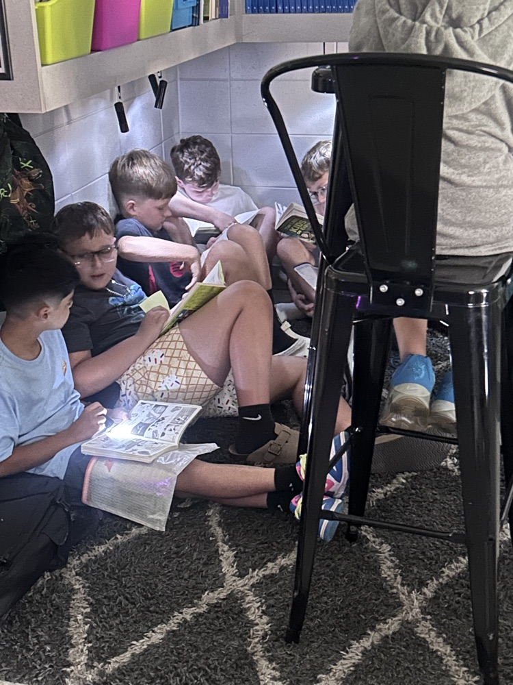 students reading by flashlight 