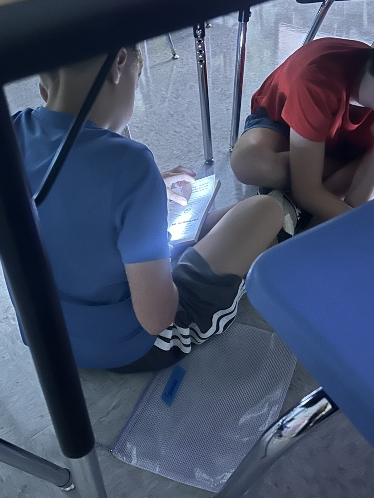 students reading by flashlight 
