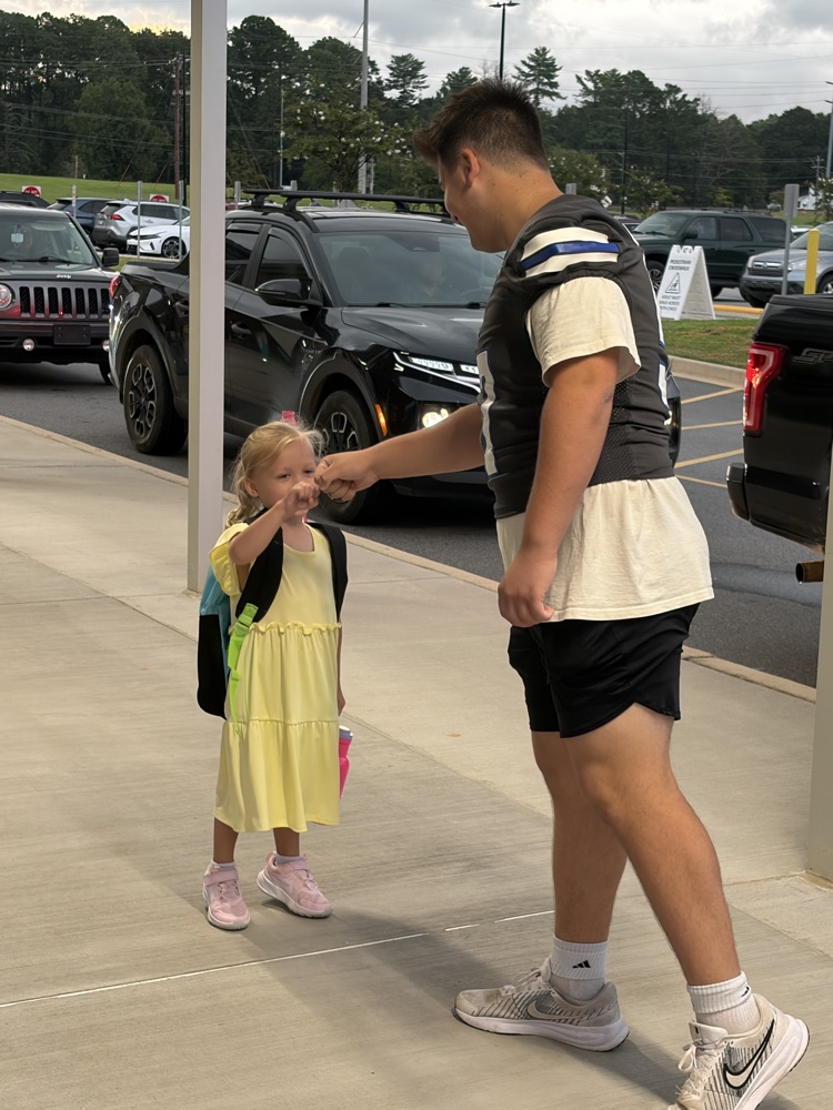 football player greeting student