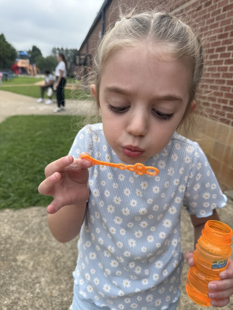 k5 students blowing bubbles outside 