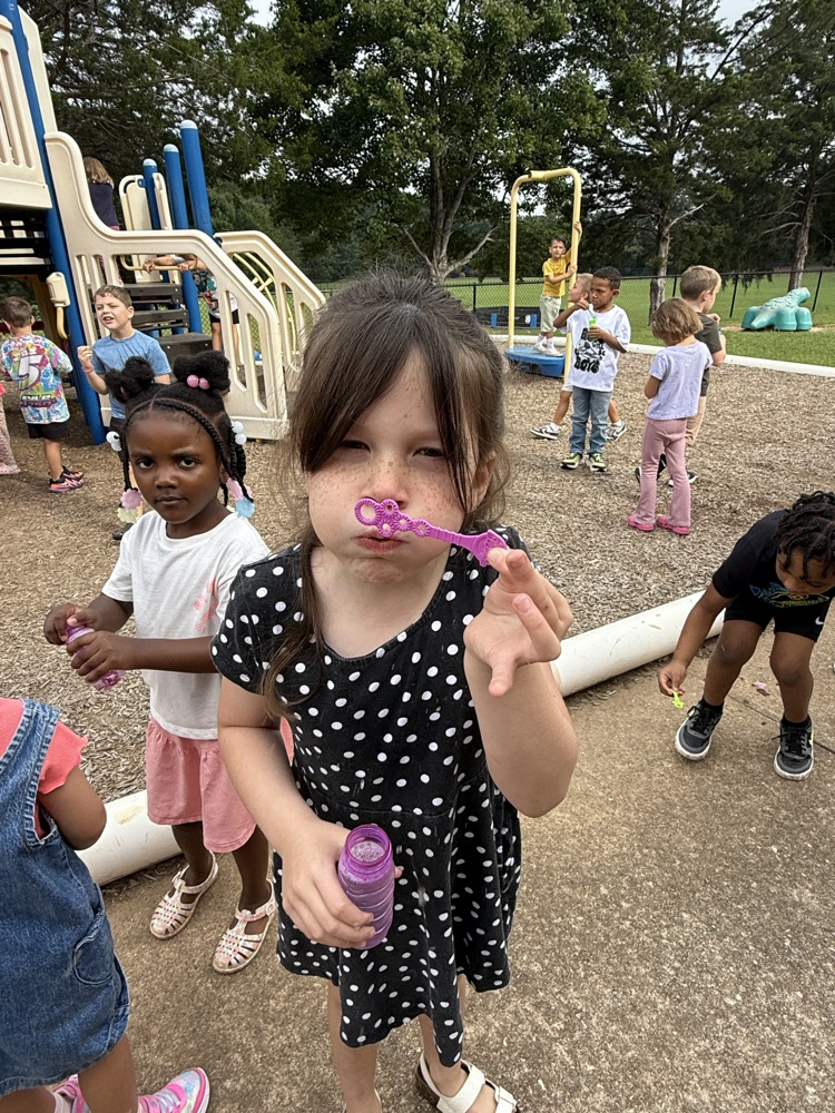 k5 students blowing bubbles outside 