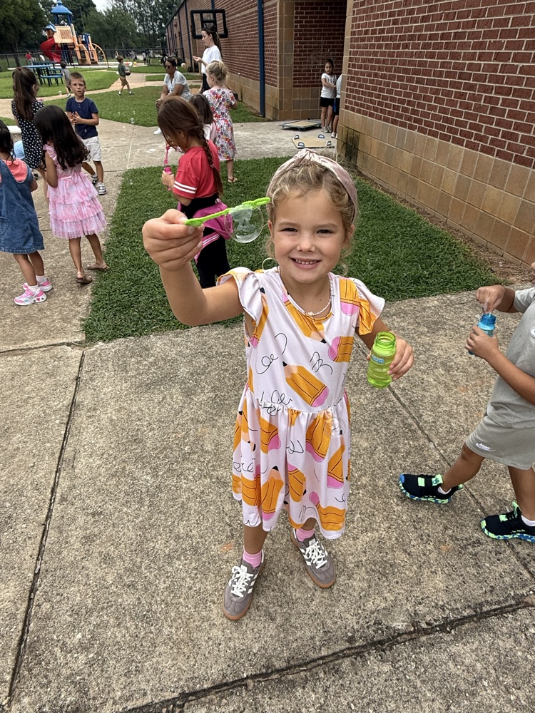 k5 students blowing bubbles outside 