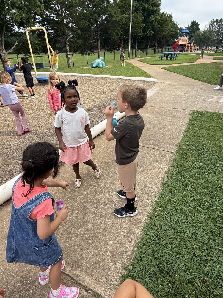 k5 students blowing bubbles outside 