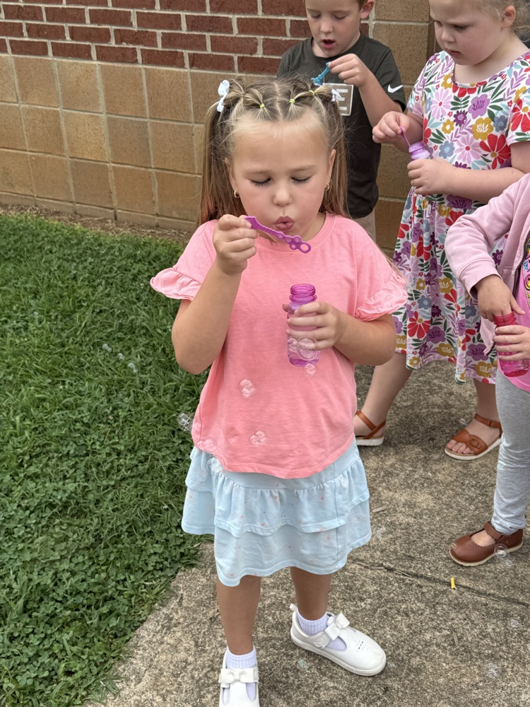 k5 students blowing bubbles outside 