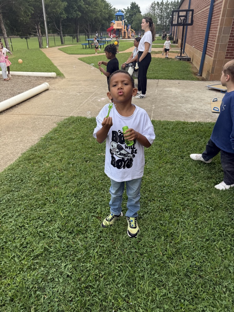 k5 students blowing bubbles outside 