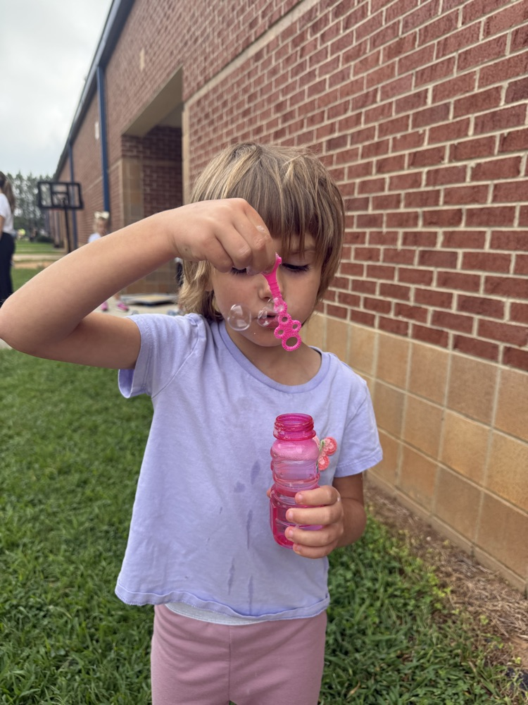 k5 students blowing bubbles outside 