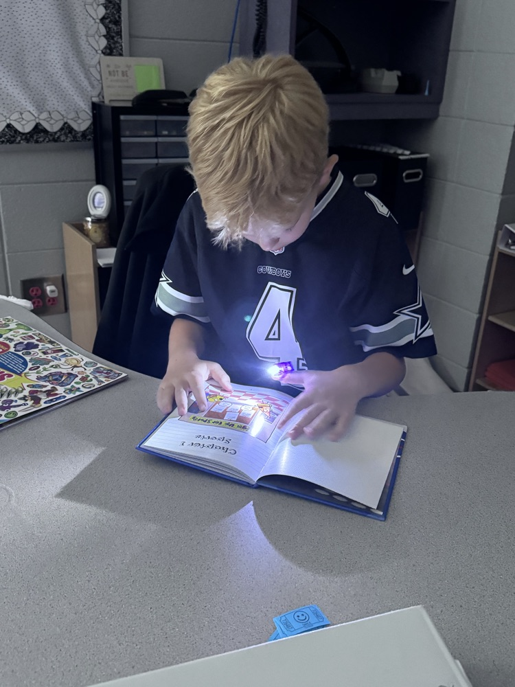 students reading with flashlights 