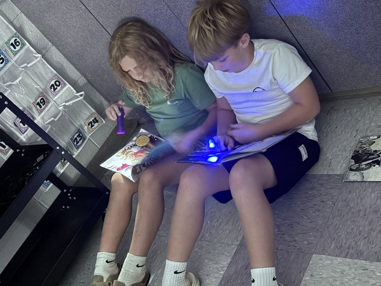 students reading with flashlights 