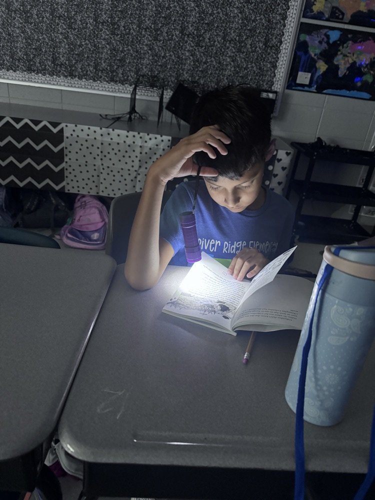 students reading with flashlights 