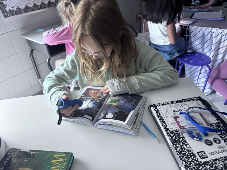 students reading with flashlights 