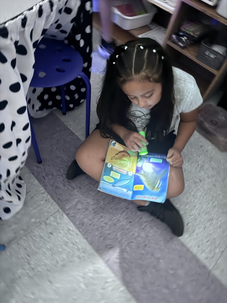 students reading with flashlights 
