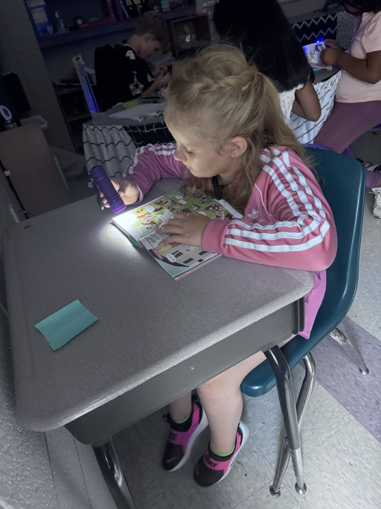 students reading with flashlights 