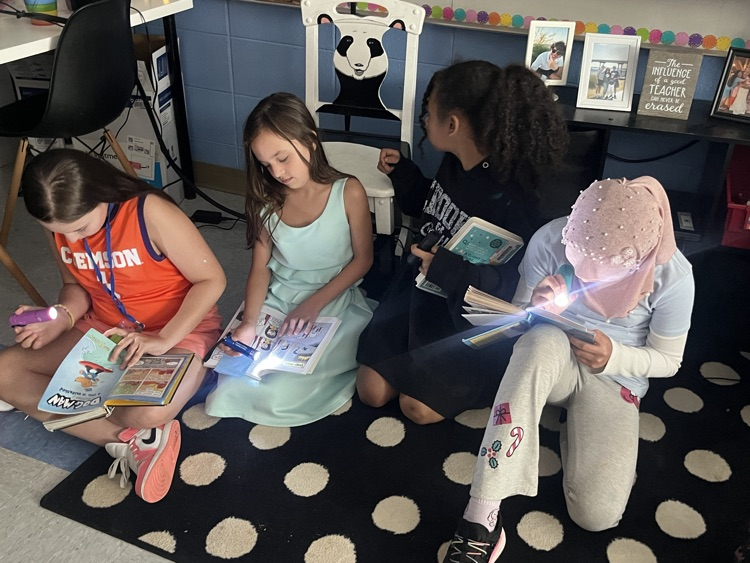 students reading with flashlights