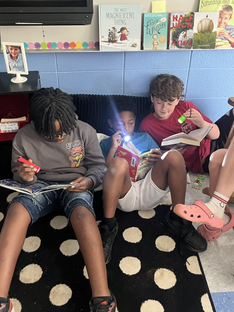 students reading with flashlights