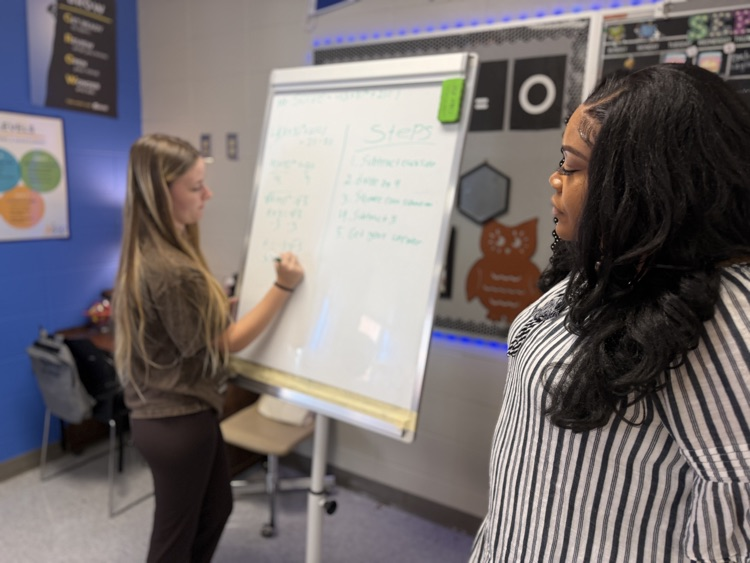 teacher watching student at board