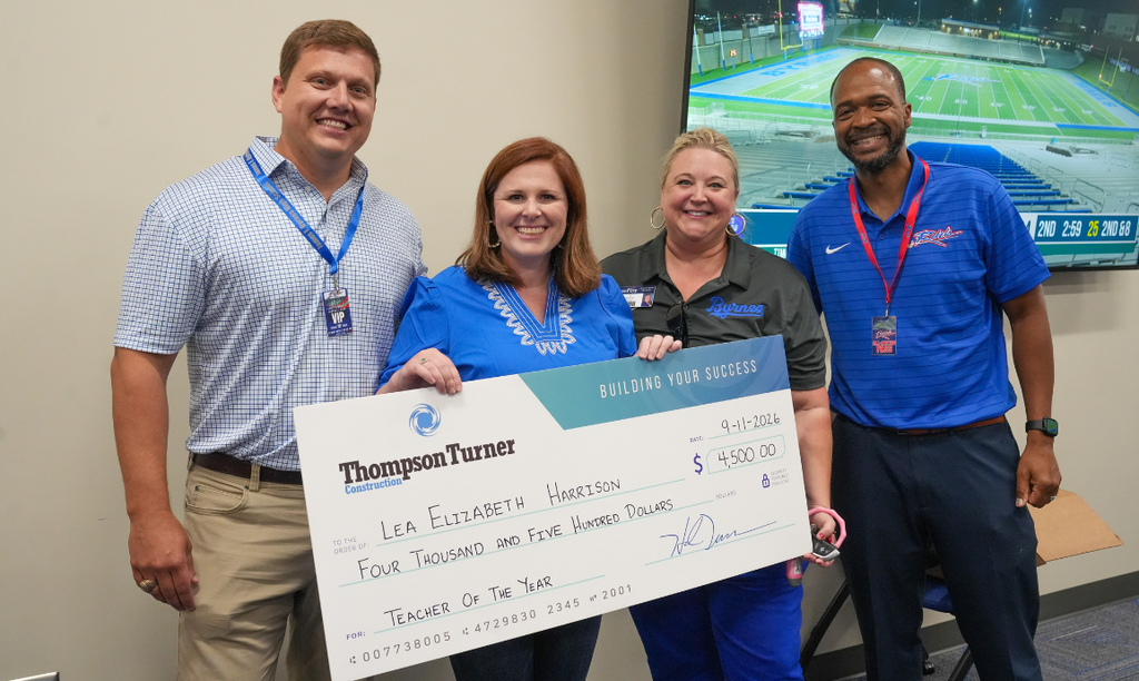 Lea Elizabeth Harrison receives check from Thompson Turner Construction