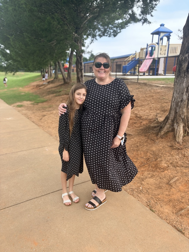 student and teacher both wearing black polka dot dresses