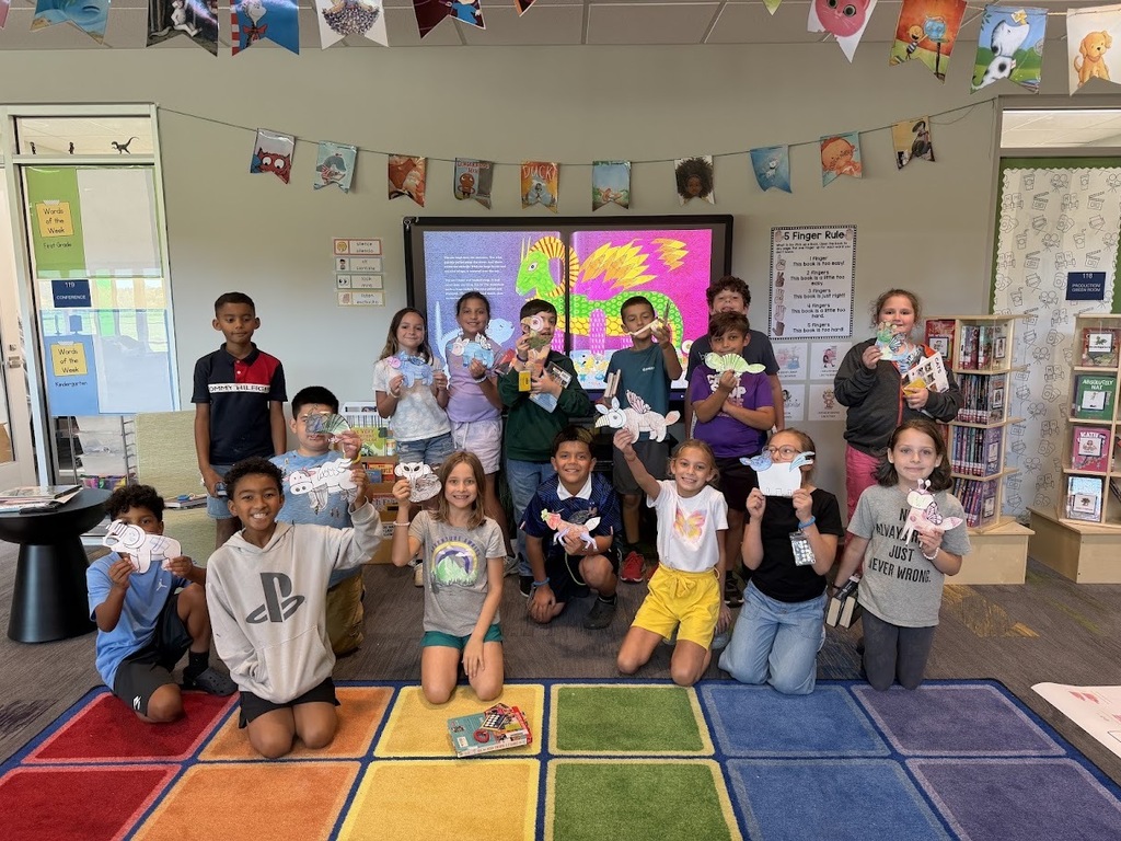 This image shows fourth graders holding up the alebrijes that they created for Hispanic Heritage Month..