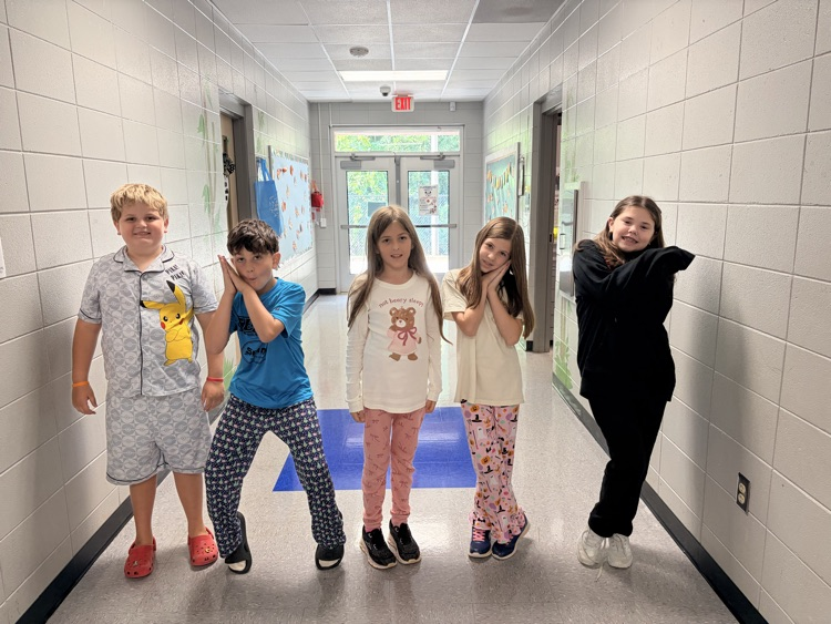 students posing in the hallway in their pjs
