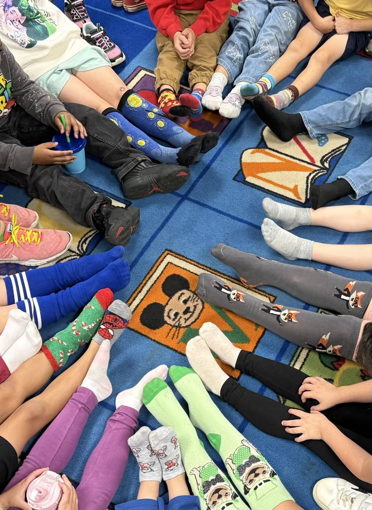 kids sitting in a circle showing silly socks 