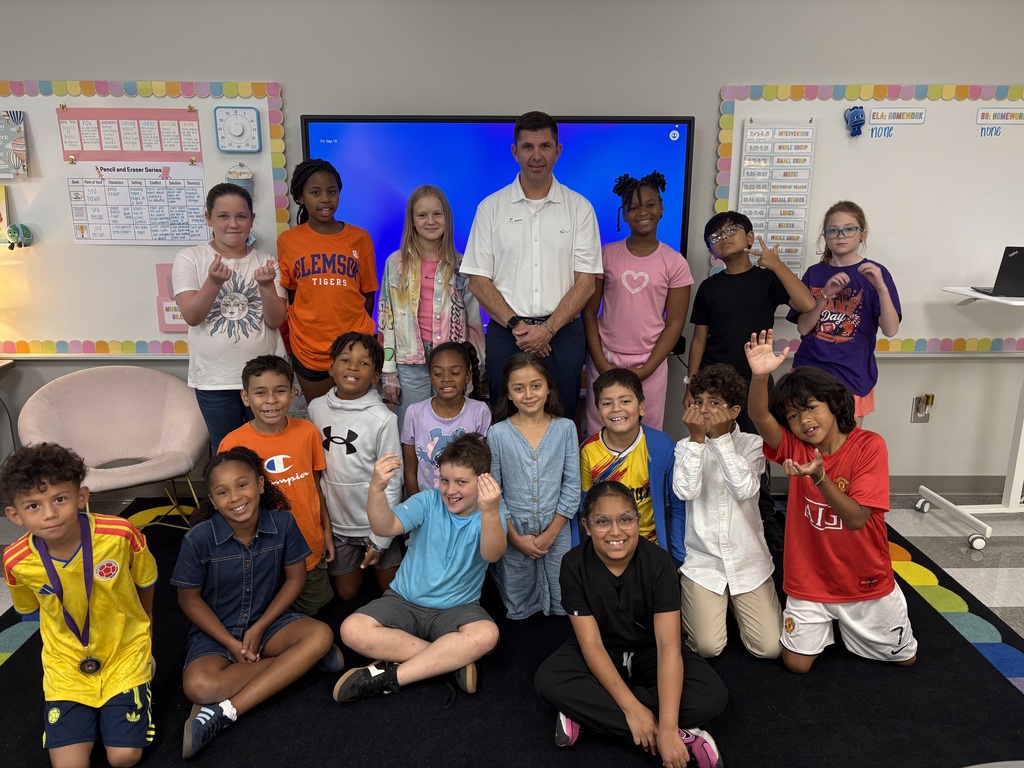 Students in Ms. Cox and Mrs. Gillepsie's class pose for a picture with their guest speaker.