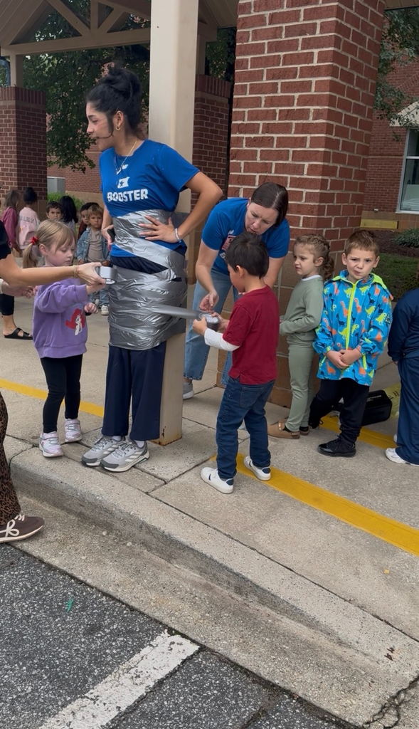 students using duct tape to tape the legs of an adult to a p