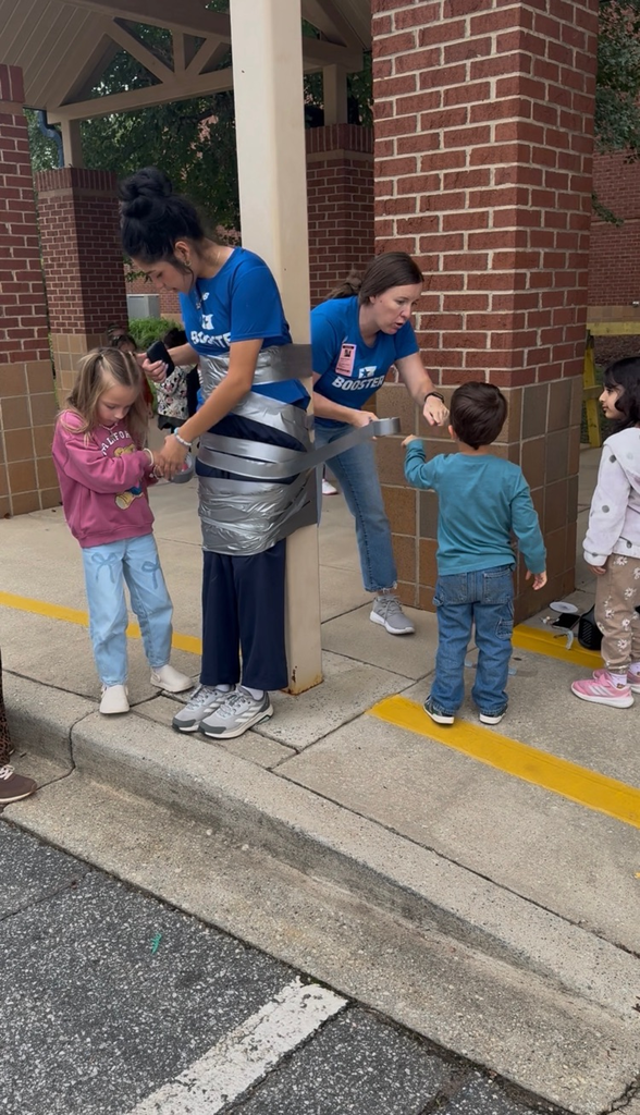 students using duct tape to tape the legs of an adult to a p