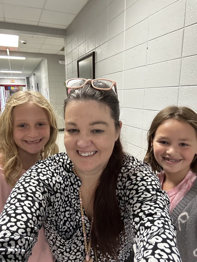 two students posing with a teacher 