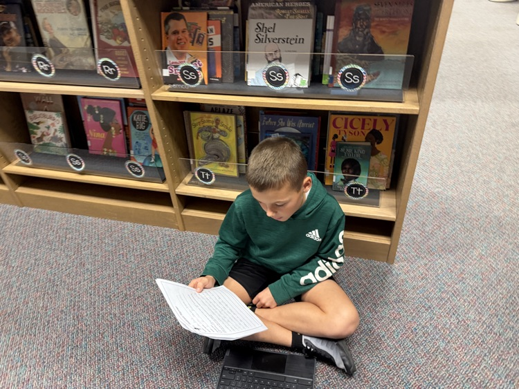 students in the library recording podcasts on laptops
