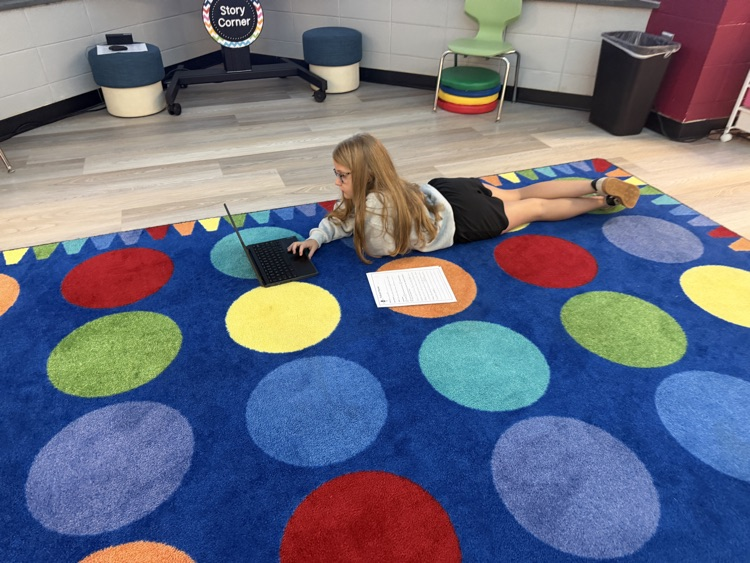 students in the library recording podcasts on laptops