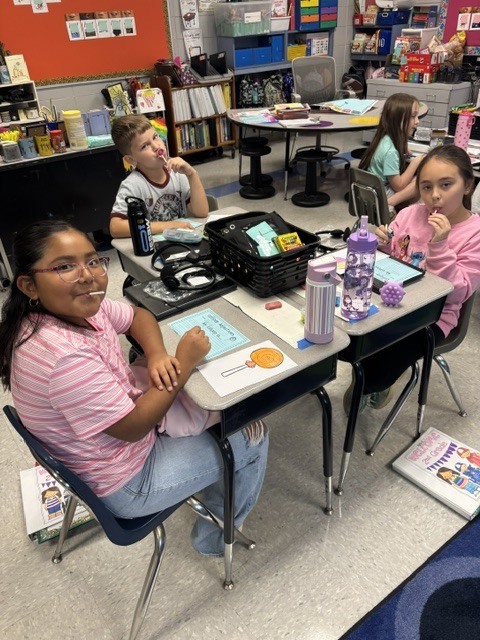 students tasting candy and describing it on paper