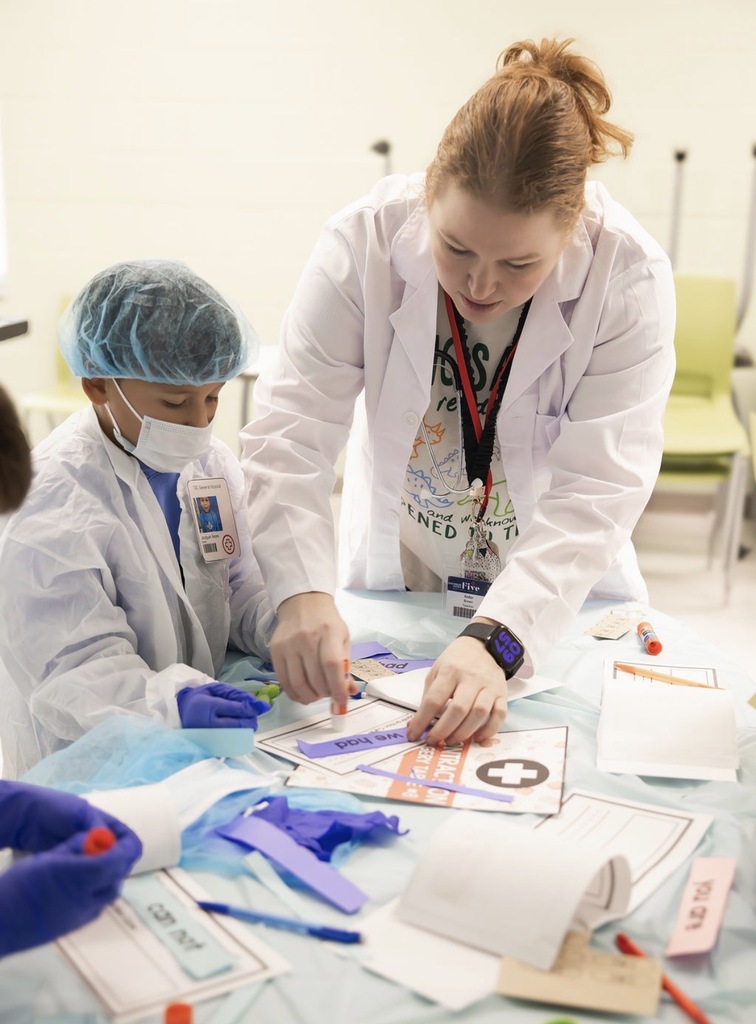 teacher helping student in surgery classroom