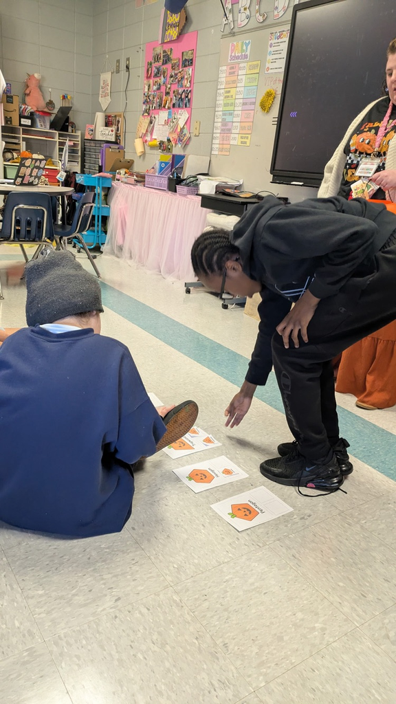 students pulling shapes out of a bucket to match