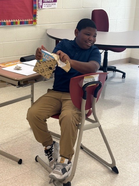Picture of student opening a wrapped book.