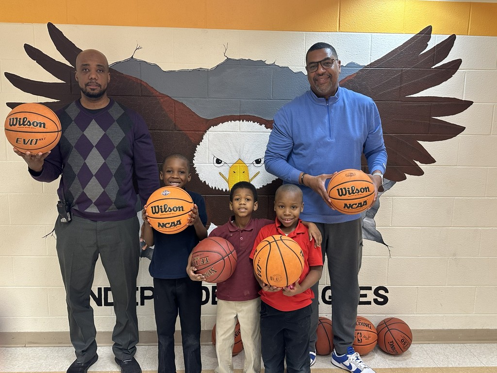 Photo of staff and students  holding basketballs