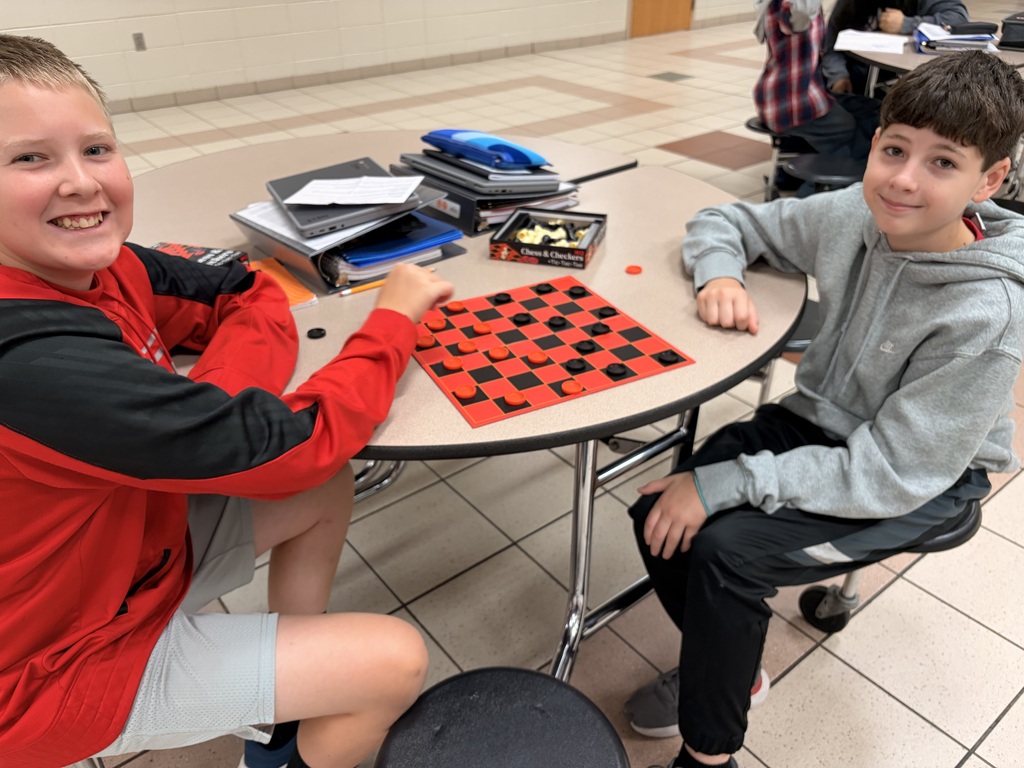 Two middle school students playing checkers.