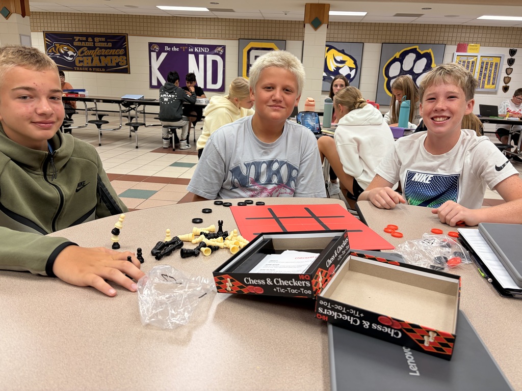 Middle school students playing a board game.