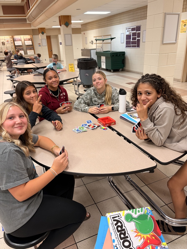A group of middle school students playing UNO.